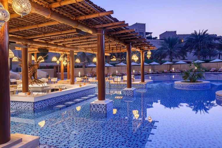 Anantara Qasr al Sarab qasr_al_sarab_desert_resort_by_anantara_restaurants_naseem_pool_bar_swim_up_bar_twilight_1920x1037