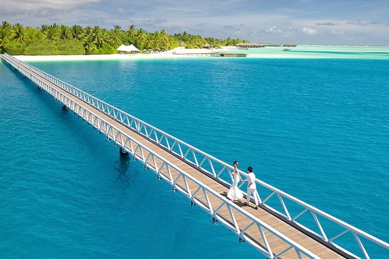 Conrad Maldives bride-and-groom-on-bridge-1063x614