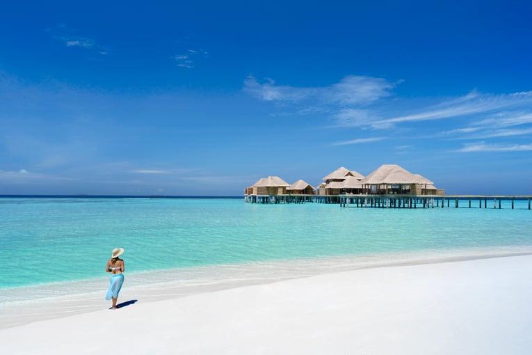 Vakkaru Maldives Resort Spa in Background Model on beach LS